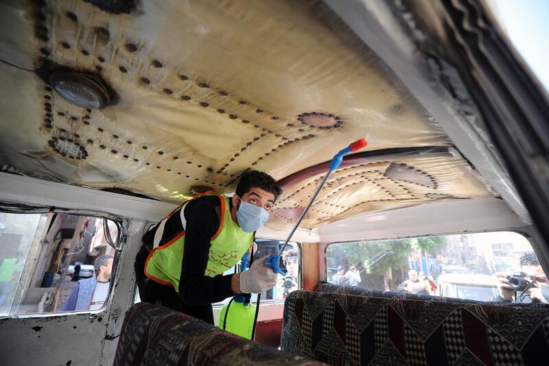 A member of a medical team sprays disinfectant as a precaution against the coronavirus outbreak inside a bus in Shobra district in Cairo, Egypt.  EPA
