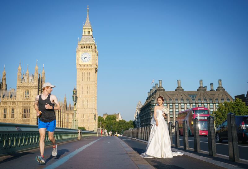 A bride poses for early-morning wedding portraits on Westminster Bridge, London, during the driest summer for 50 years. PA