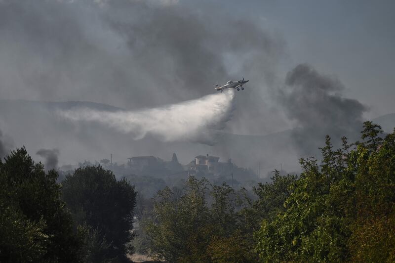 A plane sprays water as it flies over Dialekto village near Kavala, northern Greece. AFP