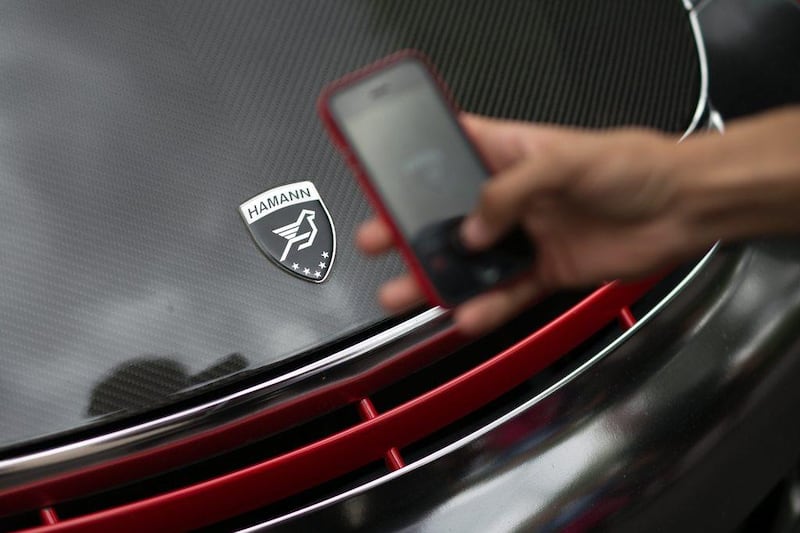 An admirer photographs the customised badge on a Kuwaiti-registered Porsche 997 GT2. Carl Court / Getty Images