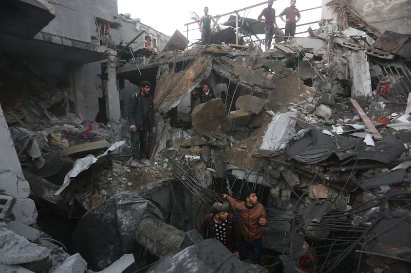 Palestinians look for survivors in Rafah. AP