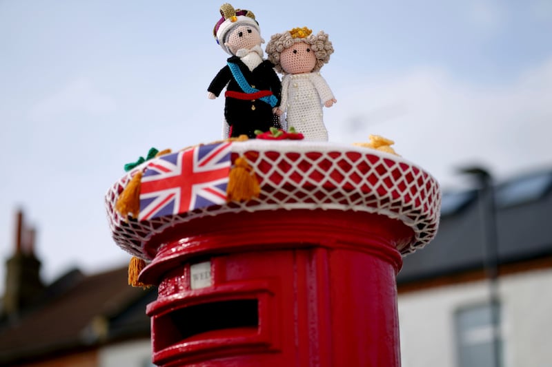 A knitted coronation-themed postbox topper in Isleworth, London. AP