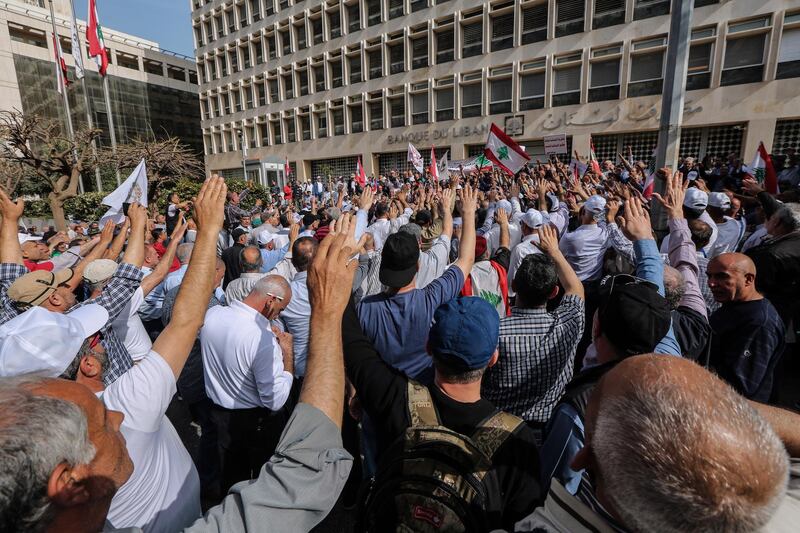epa07537659 Retired army officers and soldiers carry Lebanese flags as they block the Lebanese Central Bank during a protest in Beirut, Lebanon, 30 April 2019. According to media reports, retired military and security personnel blocked entrances to the Lebanese Central Bank and the Beirut Port as a preemptive strike against any austerity measures in the 2019 draft state budget that might affect their retirement wages or benefits.  EPA/NABIL MOUNZER