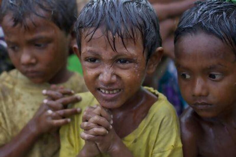 Internally displaced Rohingya boys shiver in rain in a makeshift camp for Rohingya Muslims in Sittwe, northwestern Rakhine State, Myanmar, ahead of the arrival of Cyclone Mahasen.