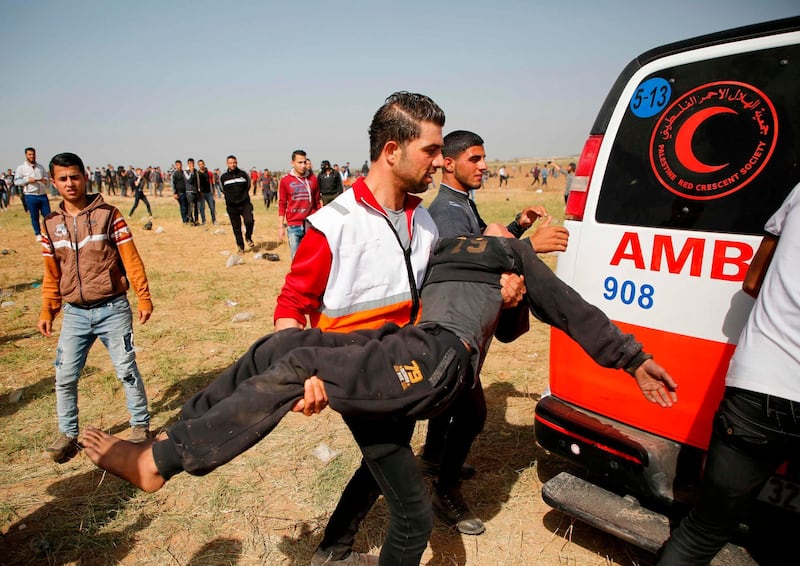 A medic carries a wounded demonstrator away.  Mohammed Abed / AFP