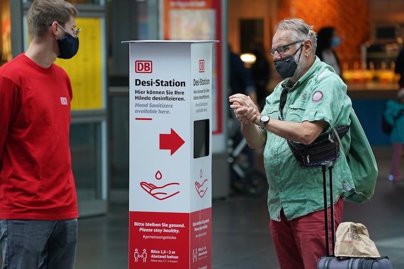 A traveller disinfects his hands at a station set up by German state rail carrier Deutsche Bahn at Hauptbahnhof main railway station during the coronavirus pandemic in Berlin.  Getty Images