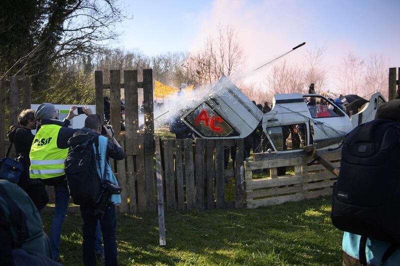 A person fires a flare as Swiss police officers begin evicting environmental activists from a quarry owned by cement maker Lafarge-Holcim located between Eclepens and La Sarraz in Western Switzerland. EPA