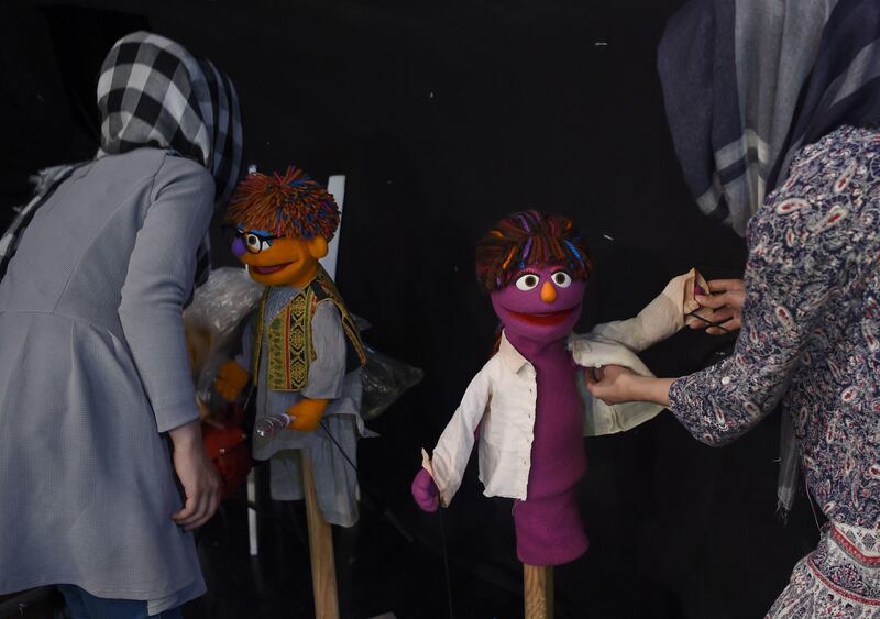 Afghan puppeteers Raziya Nazaria, left, and Mansoora Shirzad dress Sesame Street muppets Zeerak and Zari ahead of recording at a television studio in Kabul.