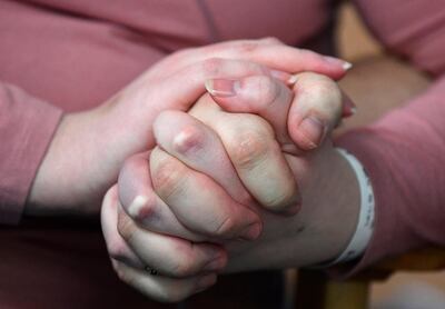 Elizabeth Kerr, 31, and Simon O'Brien, 36, hold hands in a COVID-19 ward, days after they married in an ICU (Intensive Care Unit) when both had become critically ill with the coronavirus disease (COVID-19), and were uncertain of their chances of surviving, in Milton Keynes University Hospital, Milton Keynes, Britain, January 20, 2021. Picture taken January 20, 2021. REUTERS/Toby Melville