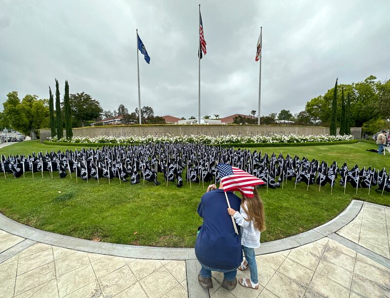 Jim Linehan and his granddaughter Ellie Paxton, 5, at the Richard Nixon Presidential Library, in Yorba Linda, California, where flags were flown to celebrate the 50th anniversary of the return of US prisoners of war from Vietnam. AP