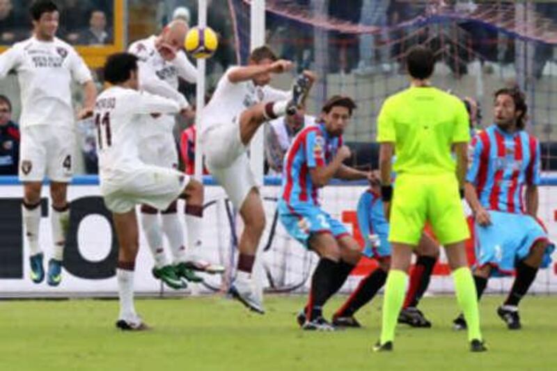 The Catania forward Gianvito Plasmati, far right, is seen with his shorts half down as teammate Guiseppe Mascara scores a free-kick past the distracted Torino keeper Matteo Sereni.