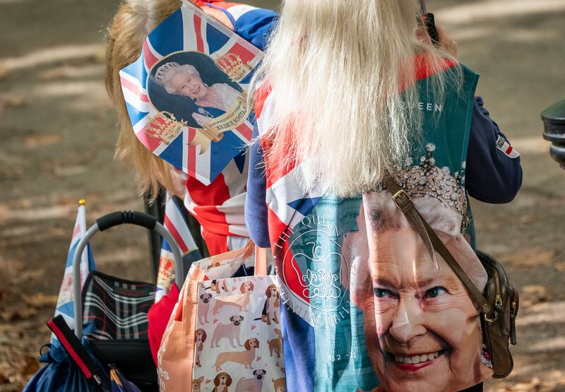 A mourner at The Mall decorated with images of Queen Elizabeth. PA
