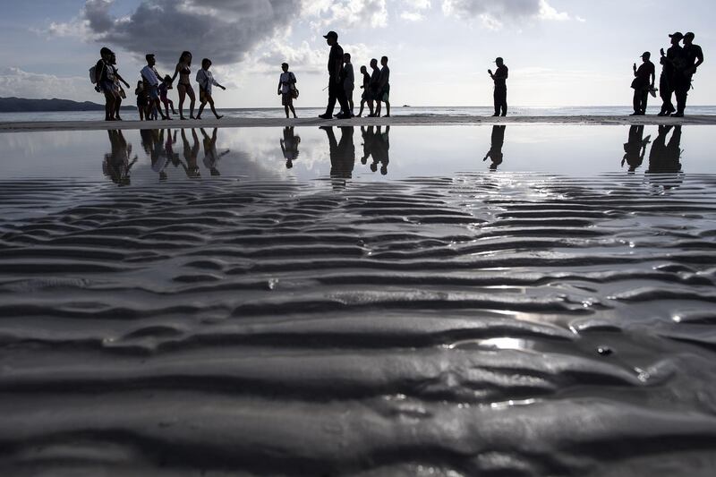 Tourists visit the beach. AFP