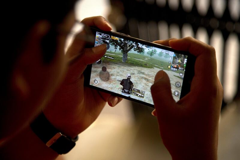 An Indian boy plays an online game PUBG on his mobile phone sitting outside his house  in Hyderabad, India, Friday, April 5, 2019. A boyâ€™s suicide in India after his mother scolded him for playing the popular online game PlayerUnknownâ€™s Battlegrounds has inflamed a debate across the country over whether the game should be banned. (AP Photo/ Mahesh Kumar A.)
