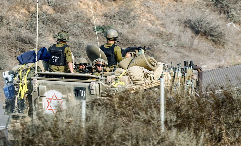 Israeli soldiers in an armoured personnel carrier on patrol near Israel's border with Gaza. EPA