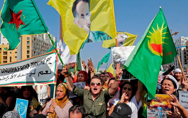 Kurdish protesters wave their national flags as well as a flag bearing the portrait of jailed Kurdish militant leader Abdullah Ocalan during a demonstration against the latest Turkish military offensive in northeastern Syria, in central Beirut's Martyrs' Square.  AFP