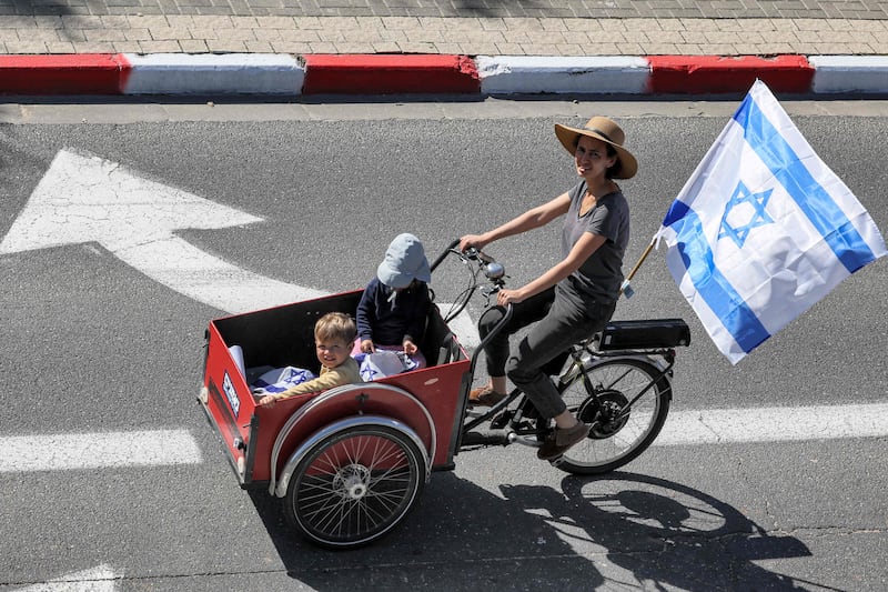 A woman rides with a cart-cycle with children in Tel Aviv. AFP