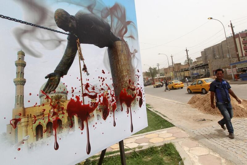 An Iraqi man walks past a billboard depicting the fall of the statue of executed dictator Saddam Hussein in Baghdad. A violent and grisly Iraq is the setting for The Corpse Exhibition: And Other Stories of Iraq by Hassan Blasim, a collection of short stories in which dead bodies are resurrected and able to speak. Ahmad Al Rubaye / AFP

