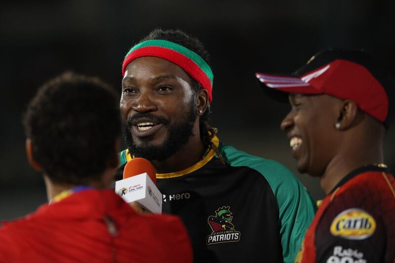 PORT OF SPAIN, TRINIDAD AND TOBAGO - AUGUST 11:  In this handout image provided by CPL T20, Chris Gayle captain of St Kitts and Nevis Patriots is interviewed by Mel Jones as Dwayne Bravo captain of the Trinbago Knight Riders looks on during the Hero Caribbean Premier League match between Trinbago Knight Riders and St Kitts and Nevis Patriots at Queen's Park Oval on August 11, 2018 in Port of Spain, Trinidad And Tobago. (Photo by Ashley Allen - CPL T20/Getty Images)