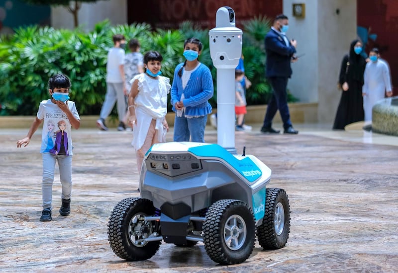 Abu Dhabi, United Arab Emirates, August 19, 2020.  
   Children are amazed at a roving robot on wheels which does thermal checks around the Yas Mall.
Victor Besa /The National
Section:  NA
Reporter:  Haneen Dajani