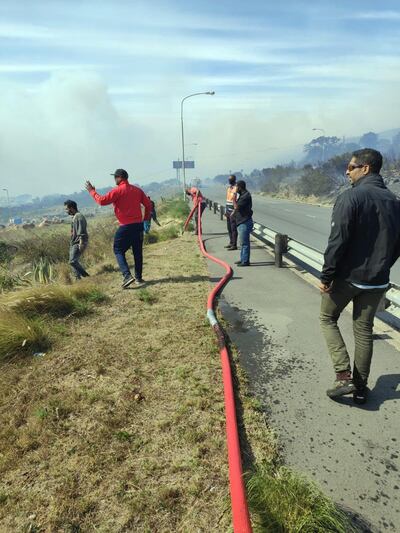 Residents at Premier Road work to put out the fire. credit Joe Mayson