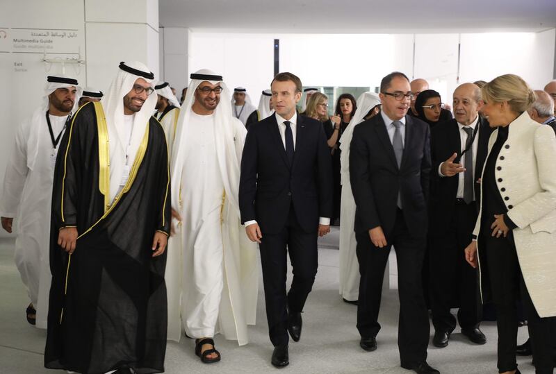 Chairman of Abu Dhabi's Tourism and Culture Authority, Mohamad Khalifa Al Mubarak, left, guides Sheikh Mohammed bin Zayed, Mr Macron through Louvre Abu Dhabi with Jean-Luc Martinez, Director of the Louvre Abu Dhabi Museum, French foreign minister Jean-Yves Le Drian and Mrs Macron.  Ludovic Marin / AFP Photo