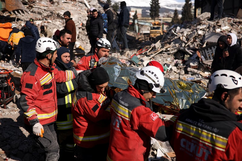 Rescuers carry a survivor at the site of a collapsed building in Kahramanmaras, Turkey. Reuters