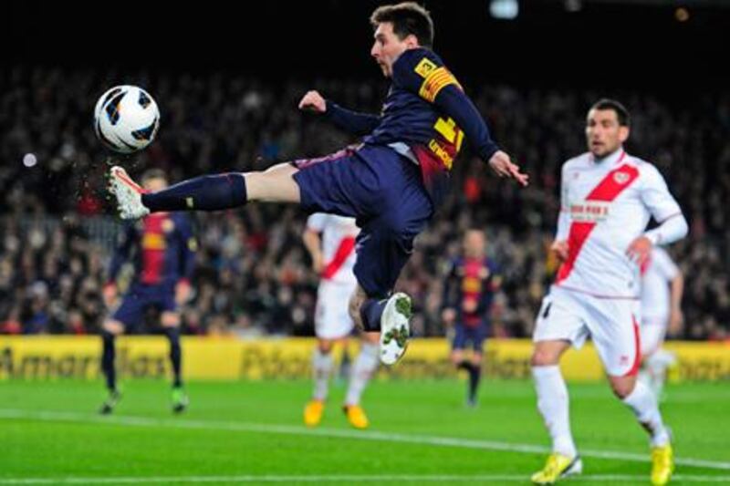 Barcelona's Lionel Messi leaps to meet the ball ahead of Rayo Vallecano's Mikel Labaka.