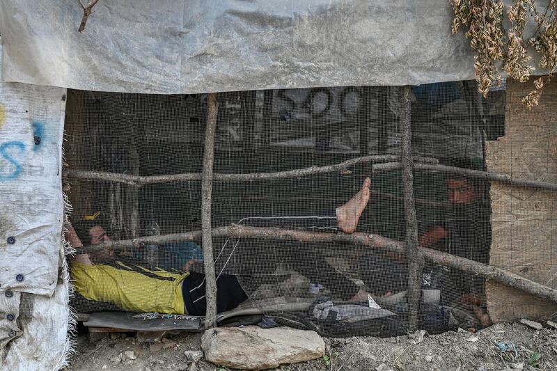 A man lying down in a improvised tents camp near the refugee camp of Moria in the island of Lesbos on June 21, 2020. - Greece's announcement that it was extending the coronavirus lockdown at its migrant camps until July 5, cancelling plans to lift the measures on June 22, coincided with World Refugee Day on June 27, 2020. (Photo by ARIS MESSINIS / AFP)