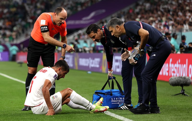 Referee Antonio Mateu asks Milad Mohammadi of Iran to get off the field of play for treatment. EPA