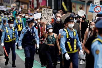 People wearing masks hold placards during a protest march over the alleged police abuse of a Turkish man, in echoes of a Black Lives Matter protest, following the death of George Floyd who died in police custody in Minneapolis, in Tokyo, Japan June 6, 2020.   REUTERS/Issei Kato