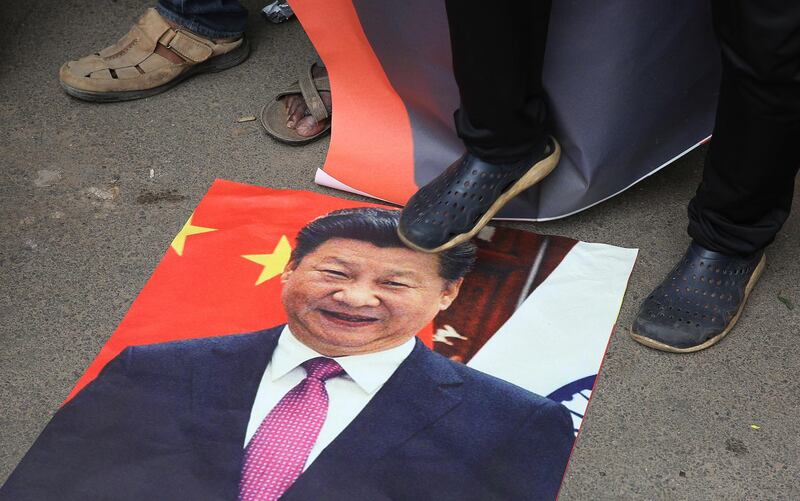 Activists hold photos of Chinese President Xi Jinping and shouts slogans against China in Bangalore. EPA