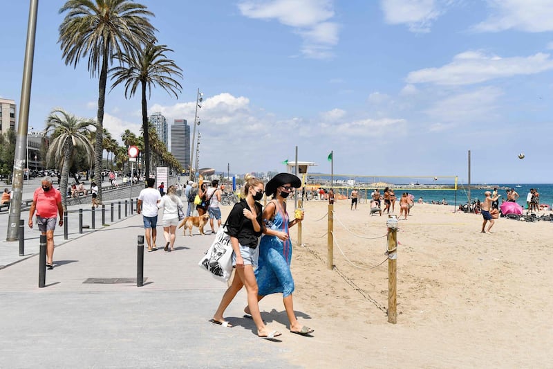 People walk on the promenade at Barceloneta Beach in Barcelona, Spain. AFP
