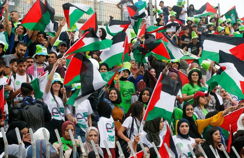 Palestine's supperters wave their national flags ahead of the World Cup 2022 Asian qualifying match between Palestine and Saudi Arabia in the town of al-Ram in the Israeli occupied West Bank. The game would mark a change in policy for Saudi Arabia, which has previously played matches against Palestine in third countries. Arab clubs and national teams have historically refused to play in the West Bank, where the Palestinian national team plays, as it required them to apply for Israeli entry permits. AFP