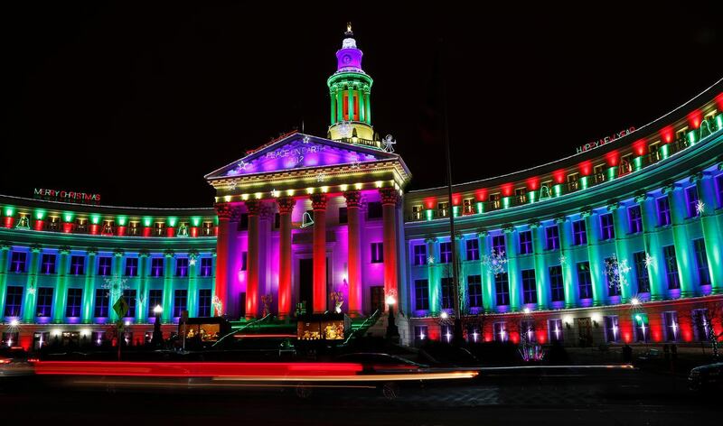 With the aid of a slow shutter speed, the lights of vehicles blur as motorists pass the traditional holiday light display illuminates the Denver City/County Building Saturday. David Zalubowski / AFP Photo