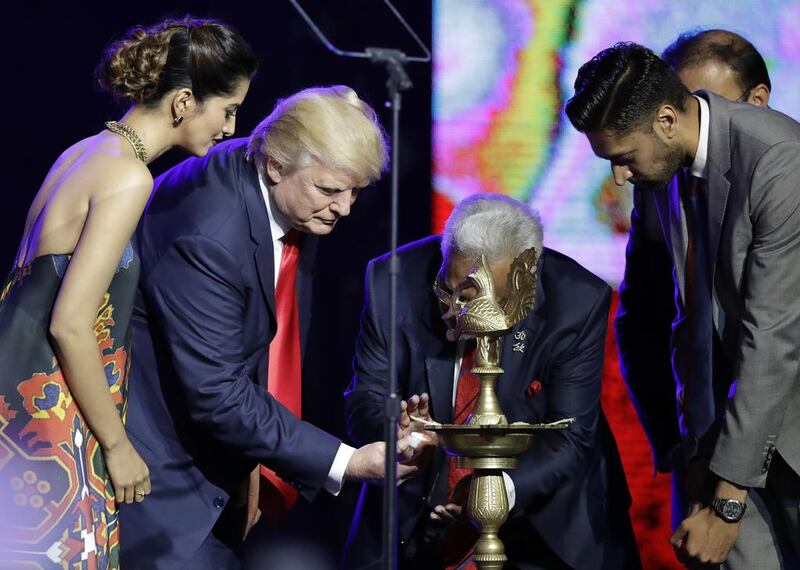 Republican presidential candidate Donald Trump is helped to light a ceremonial candle by Shalli Kumar during a charity event hosted by the Republican Hindu Coalition in Edison, New Jersey. Julio Cortez / AP Photo