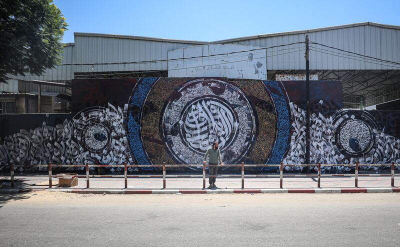 Bilal Khaled in front an example of his graffiti at Alazhar University in Gaza City