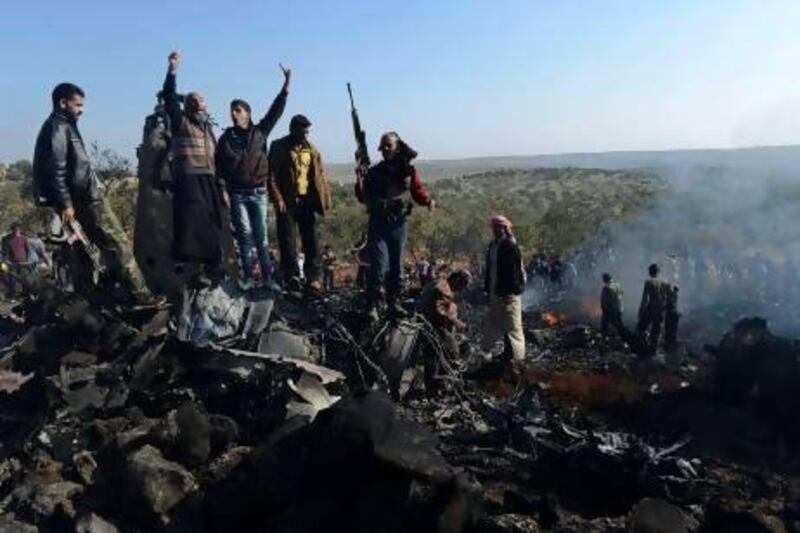 Syrian rebels celebrate on top of the remains of a government fighter jet which was shot down at Daret Ezza, on the border between the provinces of Idlib and Aleppo, on Wednesday.