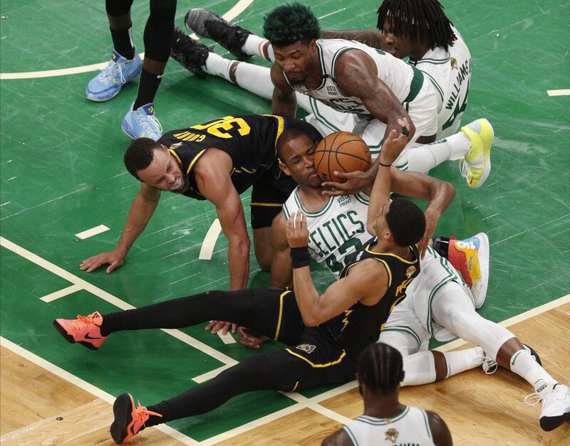 Boston Celtics' Al Horford, centre, lands on Golden State Warriors' Stephen Curry's leg, left, while going for a loose ball during a National Basketball Association (NBA) Finals playoff game. EPA