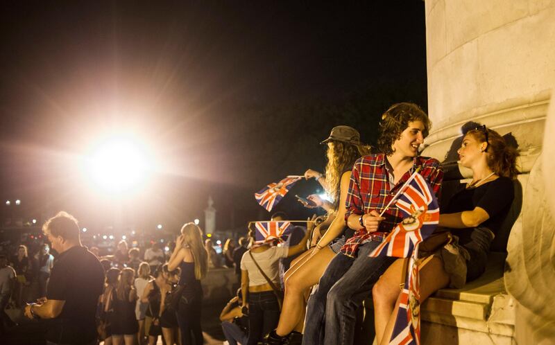 epa03797848 People waiving union jack flags celebrate  in front of Buckingham Palace, the birth of a baby boy, at 4.24pm to the Duke and Duchess of Cambridge at St Mary's Hospital, in London, Britain, 22 July 2013. Kate, the duchess of Cambridge, has given birth to a healthy boy, a royal statement said late 22 July, finally ending what the British press had dubbed the 'Great Kate Wait.' The third-in-line to the British throne weighed eight pounds and 6 ounces (3.769 kg), the statement said, noting that the duchess' husband, Prince William, was present for the birth.  EPA/BOGDAN MARAN *** Local Caption ***  03797848.jpg