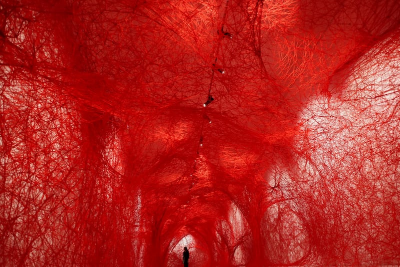 A woman stands inside The Network by Japanese artist Chiharu Shiota at the Museum of Tapestries, in Aix-en-Provence, France. Reuters