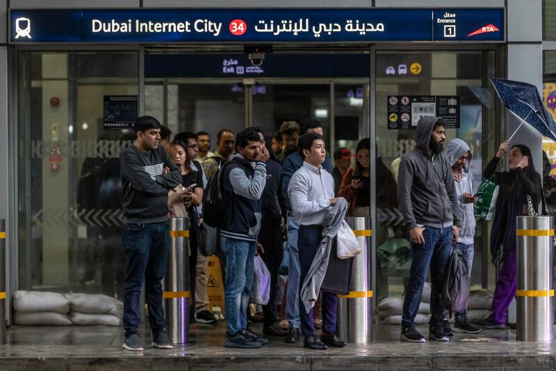 People gather at the Dubai Internet City metro station, seeking refuge from the rain. Antonie Robertson/The National