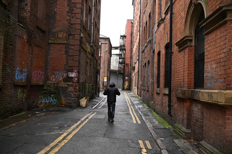 A pedestrian walks on an empty street in central Manchester. AFP