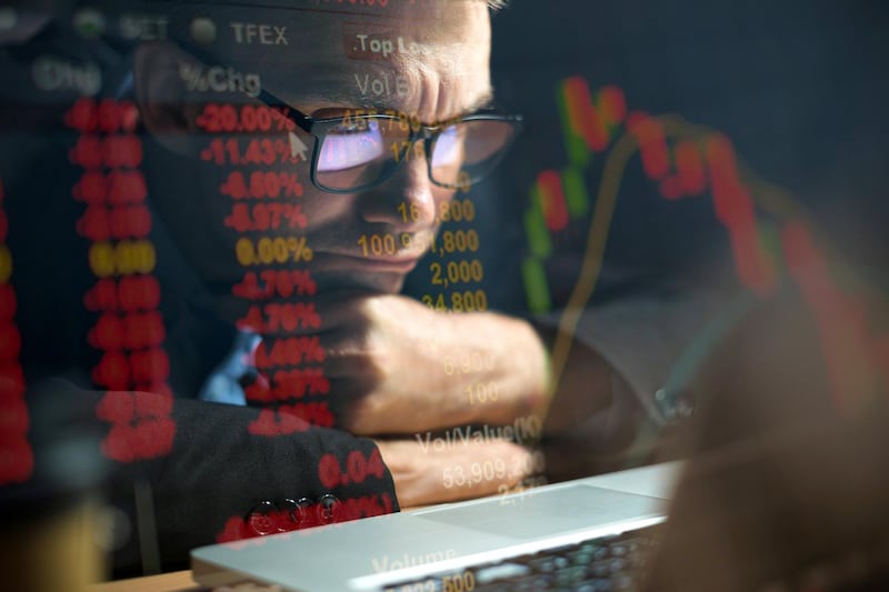 Businessman checking stock market data on computer screen and contemplating