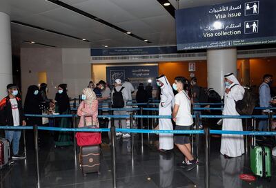 Passengers, wearing protective face mask due to the Covid-19 pandemic, stand in a queue at the Muscat international airport in the Omani capital on October 1, 2020.  / AFP / MOHAMMED MAHJOUB
