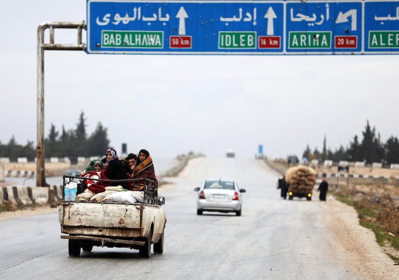 Displaced people from a village in southern Idlib head on the Damascus-Aleppo motorway towards the northern part of the rebel-held province on January 5, 2018. 
Regime troops backed up by Russian airpower are battling rebels and jihadists on the edge of northwestern Idlib province, the only one still fully beyond government control. / AFP PHOTO / OMAR HAJ KADOUR
