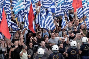 Golden Dawn supporters wave flags and shout slogans outside a court in Athens where leaders of the Greek far-right party were brought for trial on July 4, 2014. AFP