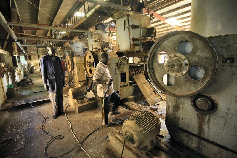 Workers operate machinery at Teital Oil Mills in the Sudanese capital Khartoum on November 24, 2019. - A year after the start of a protest movement that led to the fall of dictator Omar al-Bashir, Sudan is looking for a fresh start despite a stagnant economy. The United States in 1997 imposed a trade embargo on Sudan for hosting Al-Qaeda leader Osama bin Laden between 1992 and 1996, affecting not only international banking but also technology and trade in spare parts. While the embargo was lifted in 2017, business owners are still unable to invest in their facilities as the country is not part of the global banking system and they are unable to make international money transfers. (Photo by Ashraf SHAZLY / AFP)