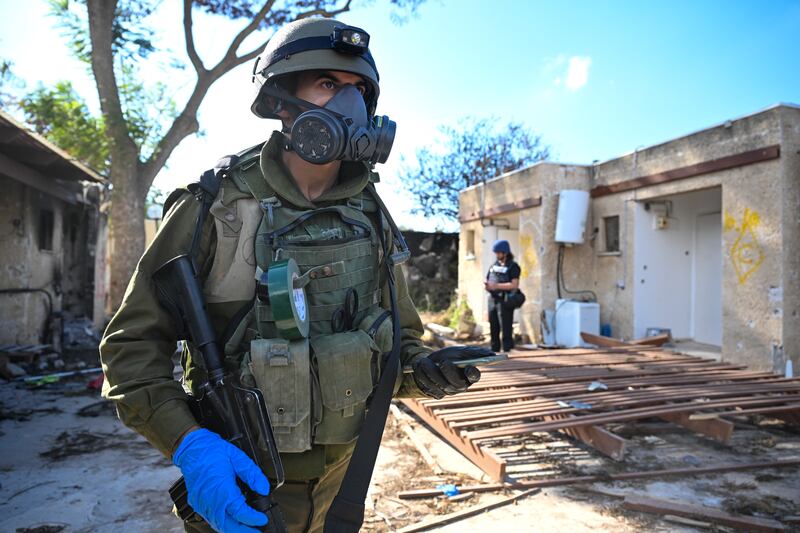 Israeli soldiers move through neighborhoods destroyed by Hamas militants after they attacked this kibbutz days earlier near the border of Gaza. Getty