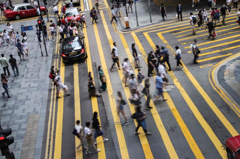 People cross a road in the Central district in Hong Kong.  AFP